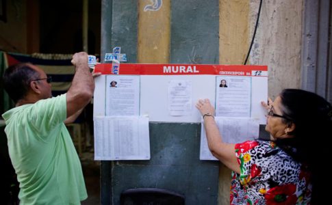 Election officials hang pictures and CVs of municipal assembly candidates moments before opening a polling station in Havana, Cuba November 26, 2017. REUTERS/Alexandre Meneghini